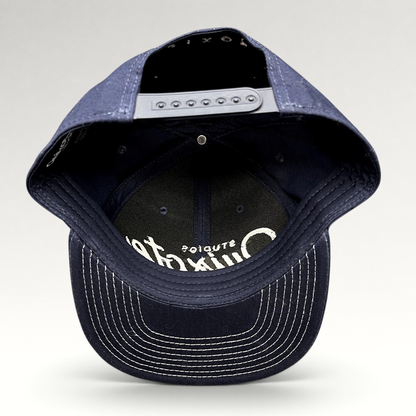 Raree Finds navy blue Quixote Studios snapback hat with white embroidered logo and adjustable plastic back closure