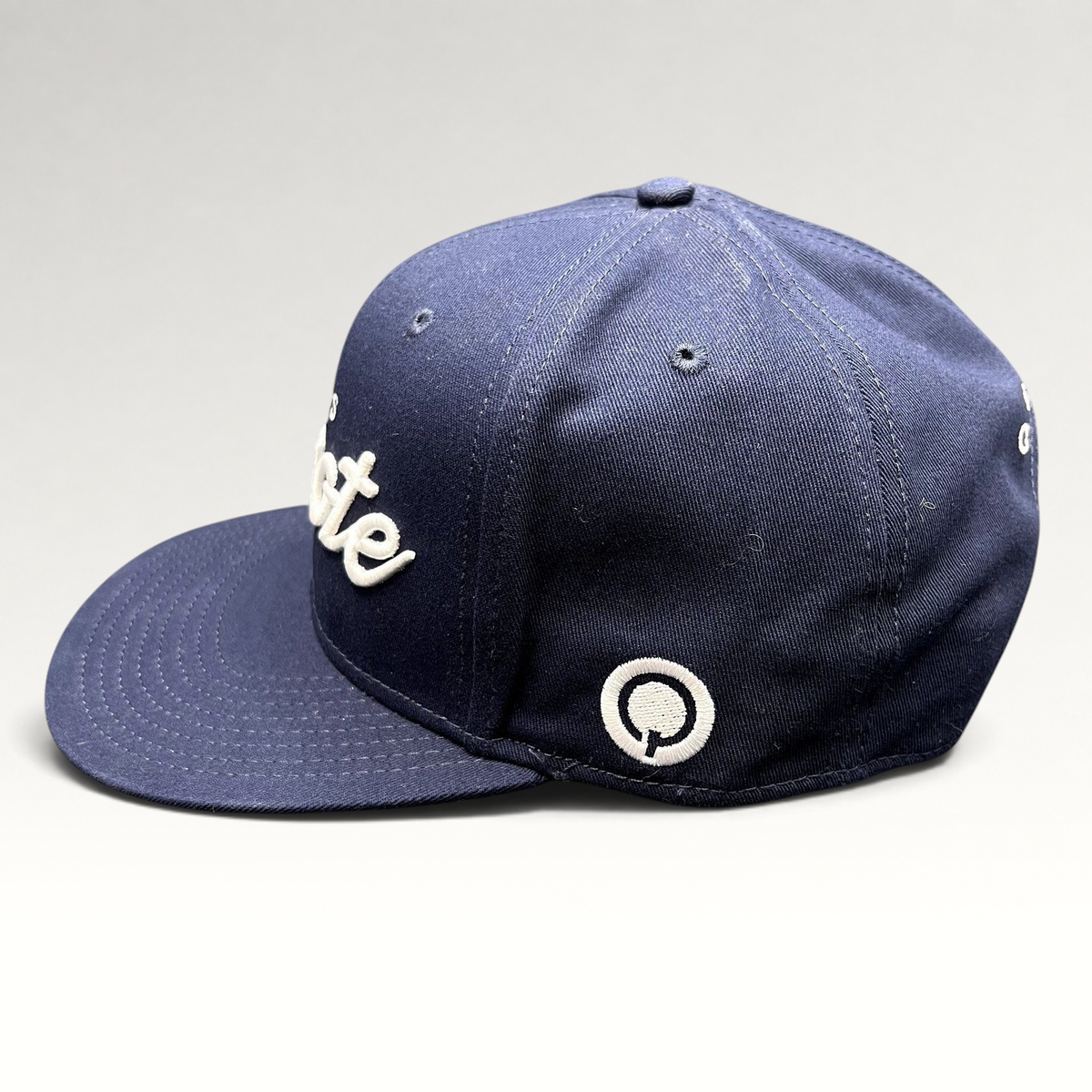 Raree Finds navy blue Quixote Studios snapback hat with white raised embroidery and flat brim