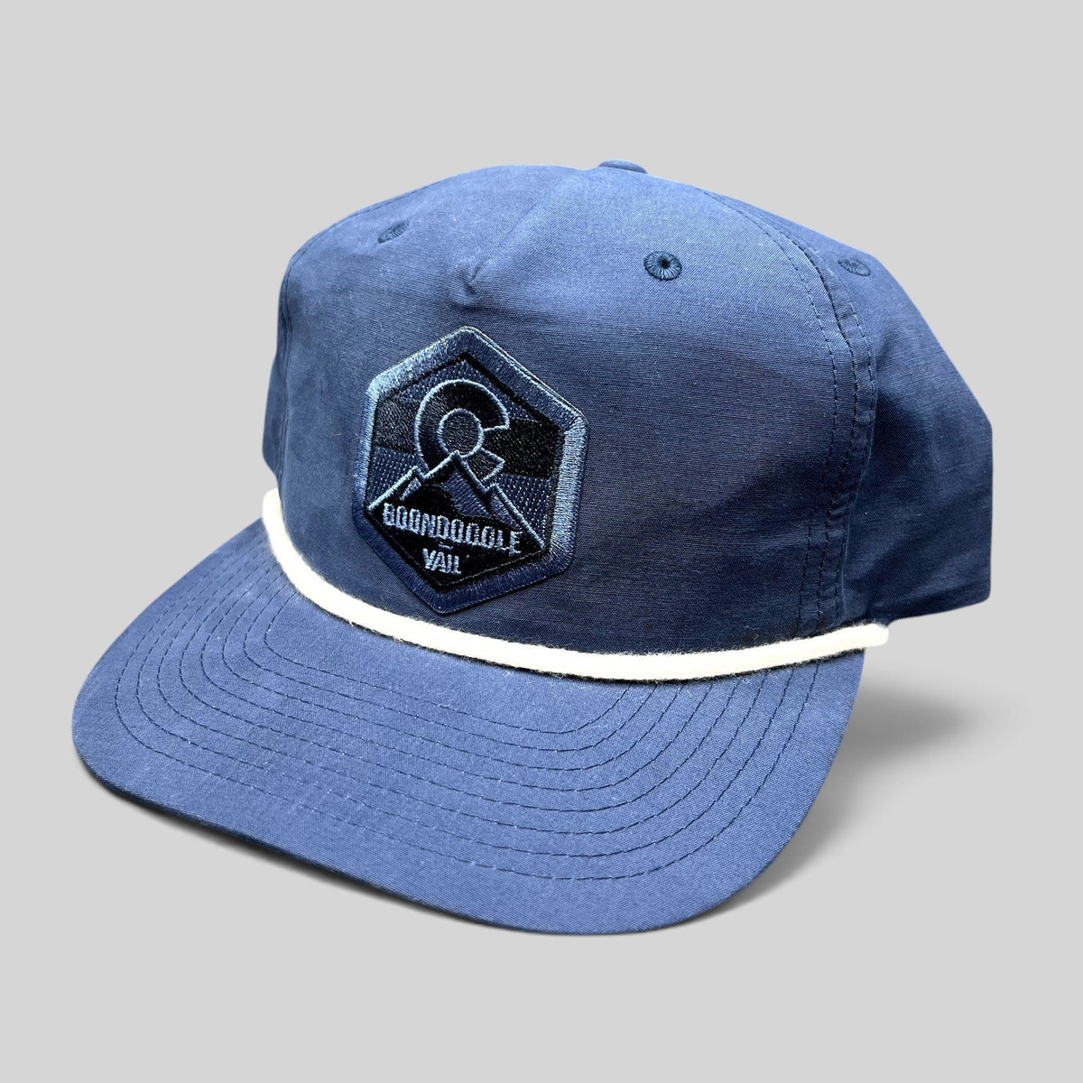 Raree Finds navy blue Richardson Outdoor snapback hat with white rope brim detail and Boondoggle Vail mountain patch.