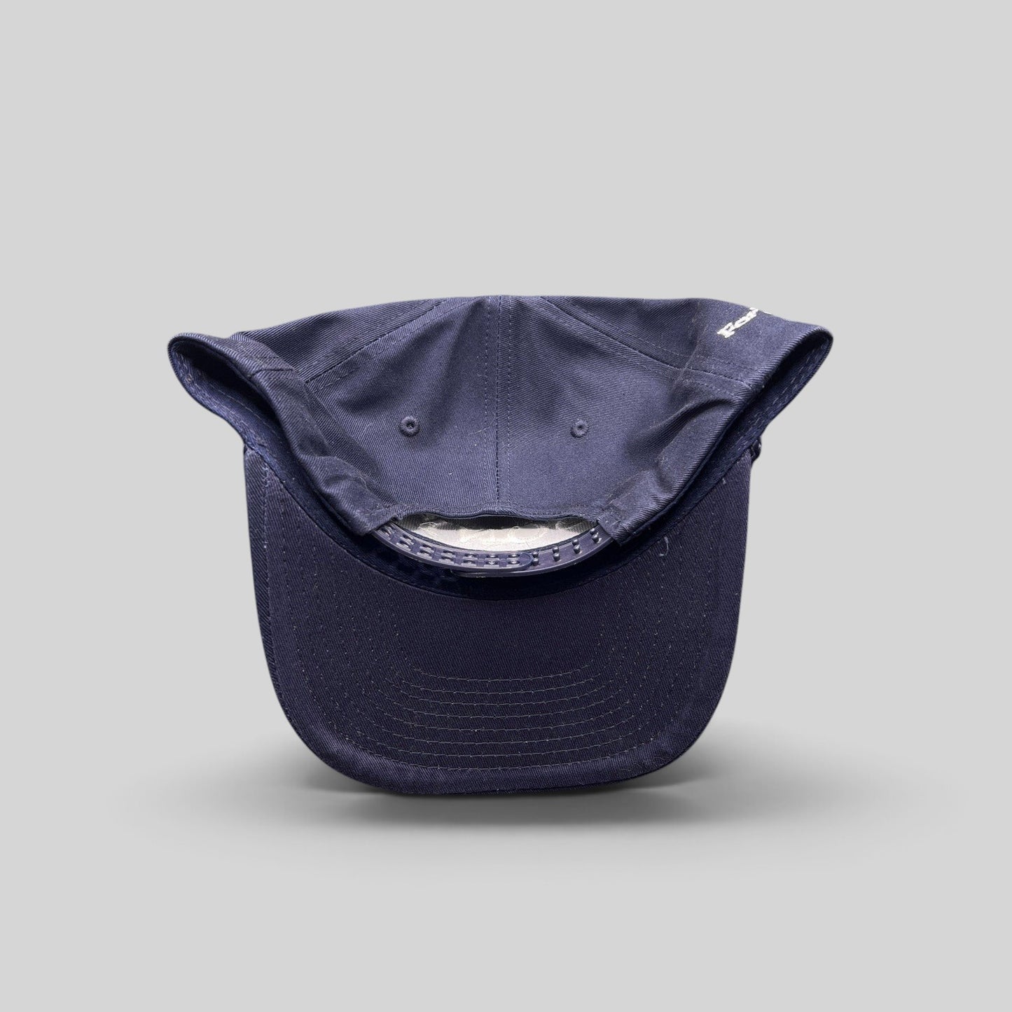 Raree Finds navy blue snapback hat with rope brim and adjustable plastic closure, viewed from the back.