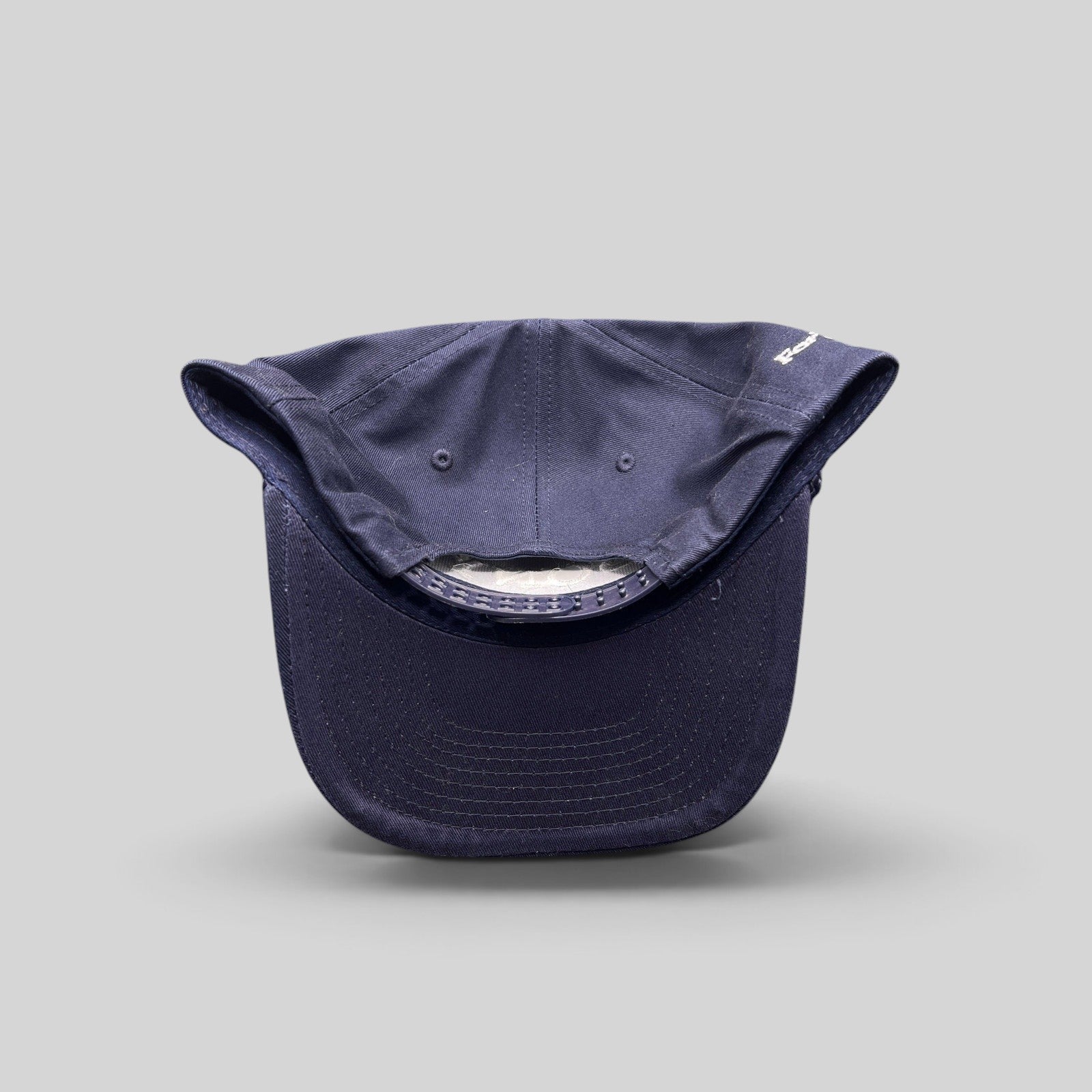 Raree Finds navy blue snapback hat with rope brim and adjustable plastic closure, viewed from the back.