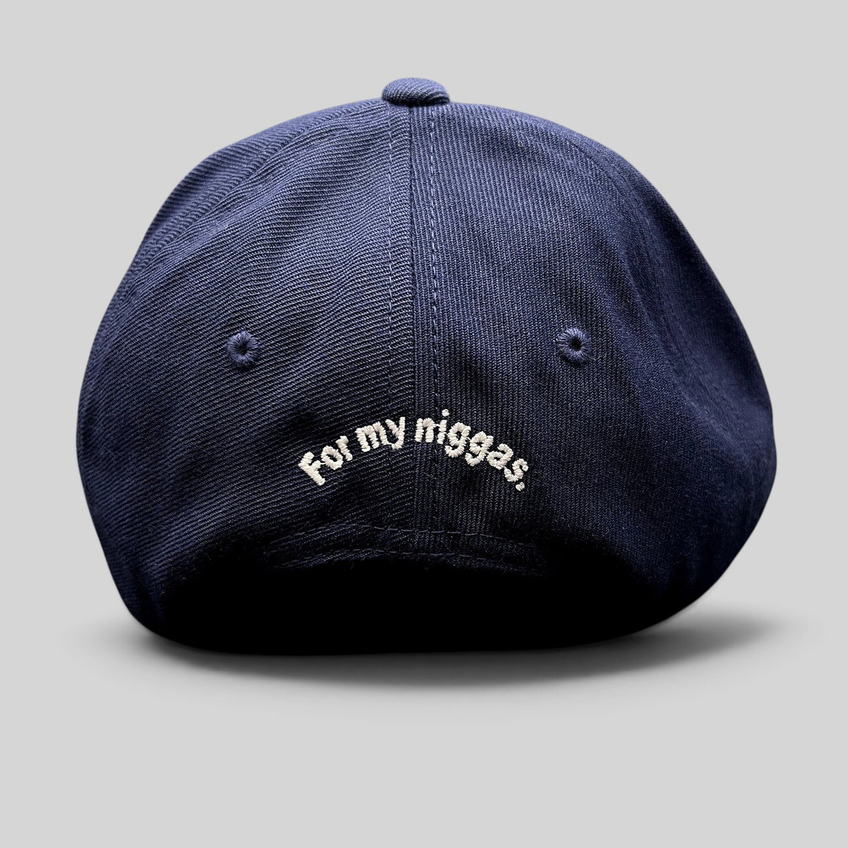 Raree Finds navy blue Yupoong Classics snapback hat with white embroidered slogan on the back