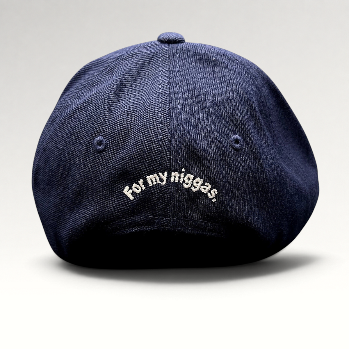 Raree Finds navy blue Yupoong Classics snapback hat with white embroidered slogan on the back