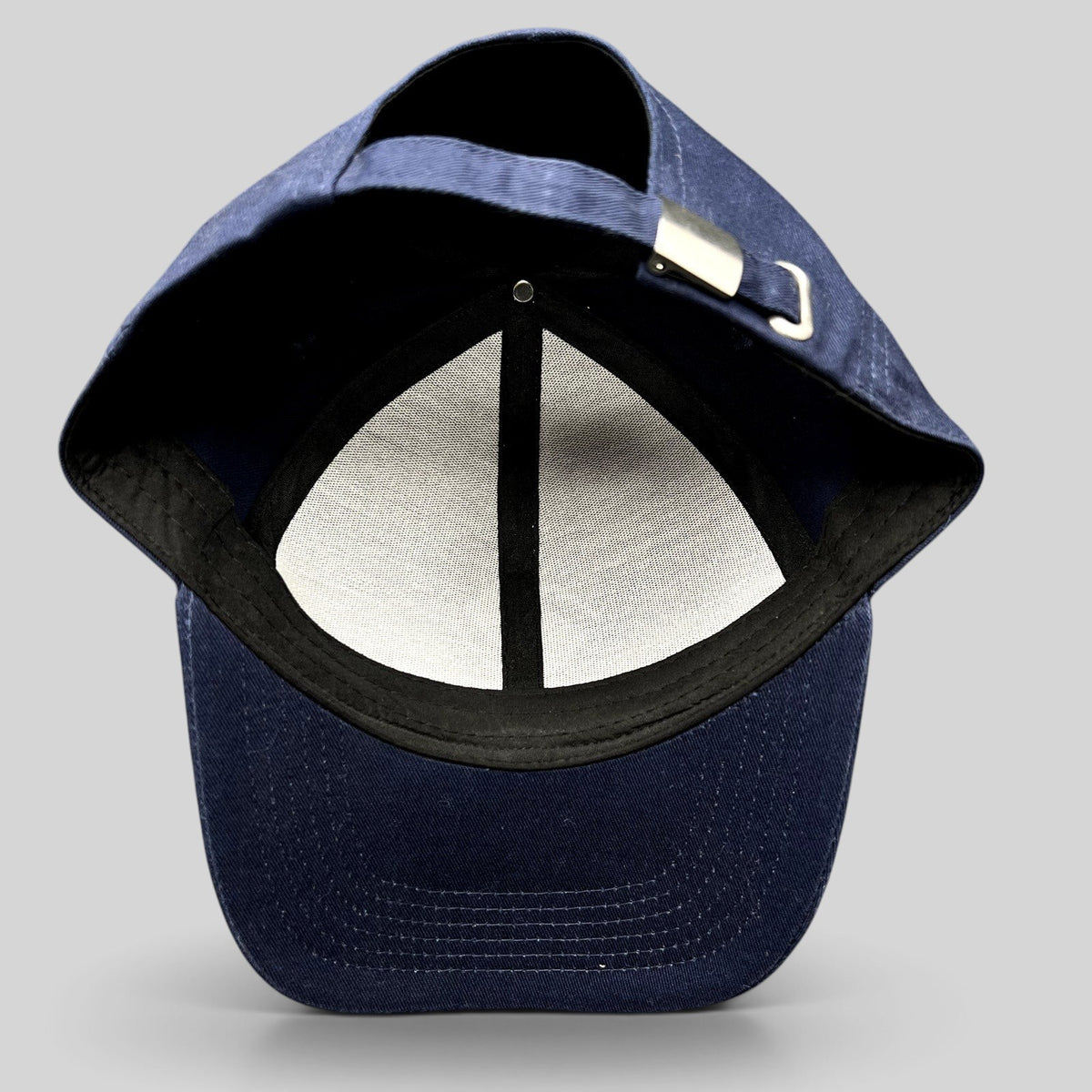 Raree Finds navy blue strapback hat showing the interior six-panel construction and adjustable metal buckle closure.