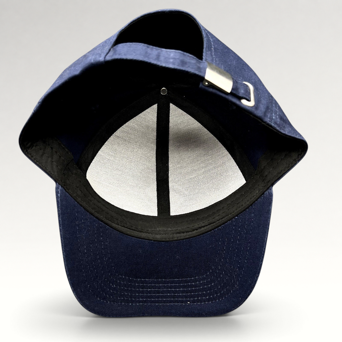 Raree Finds navy blue strapback hat showing the interior six-panel construction and adjustable metal buckle closure.