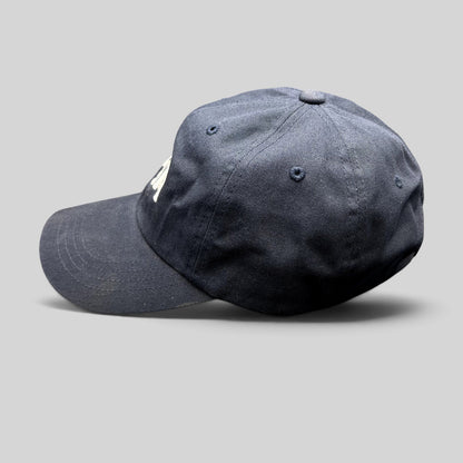 Raree Finds navy blue cotton dad cap with white embroidered Tessa logo and adjustable brass buckle strapback closure