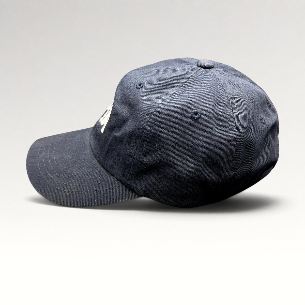 Raree Finds navy blue cotton dad cap with white embroidered Tessa logo and adjustable brass buckle strapback closure