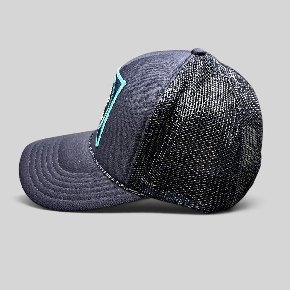 Raree Finds navy blue trucker hat with mesh back and Après Vibes embroidered patch, side profile view.