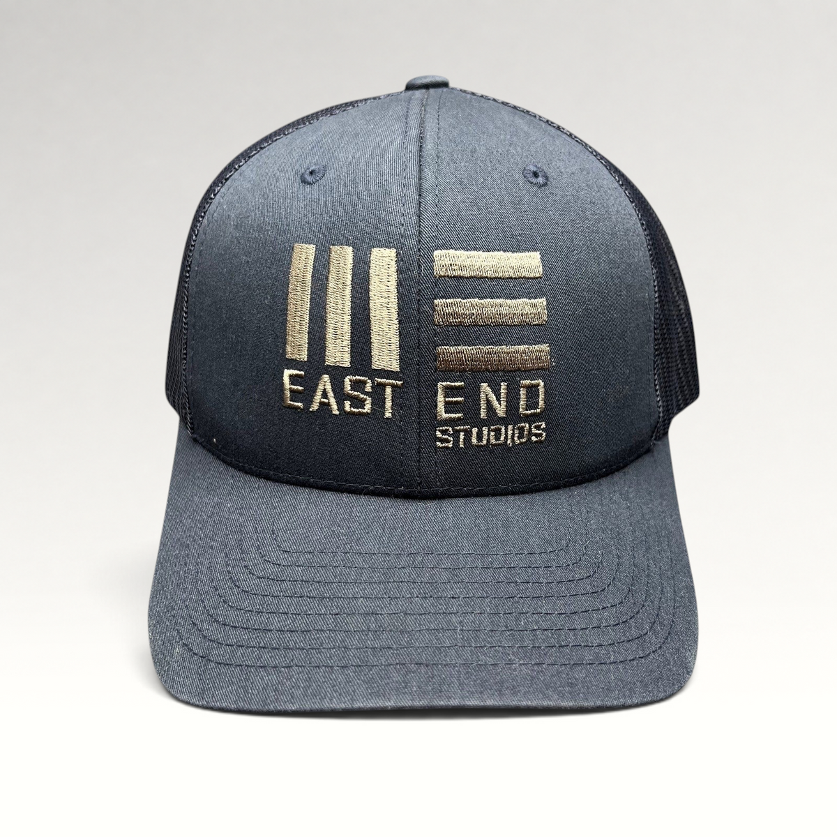 Raree Finds navy blue Yupoong Classics trucker hat with embroidered East End Studios logo and mesh back panels.