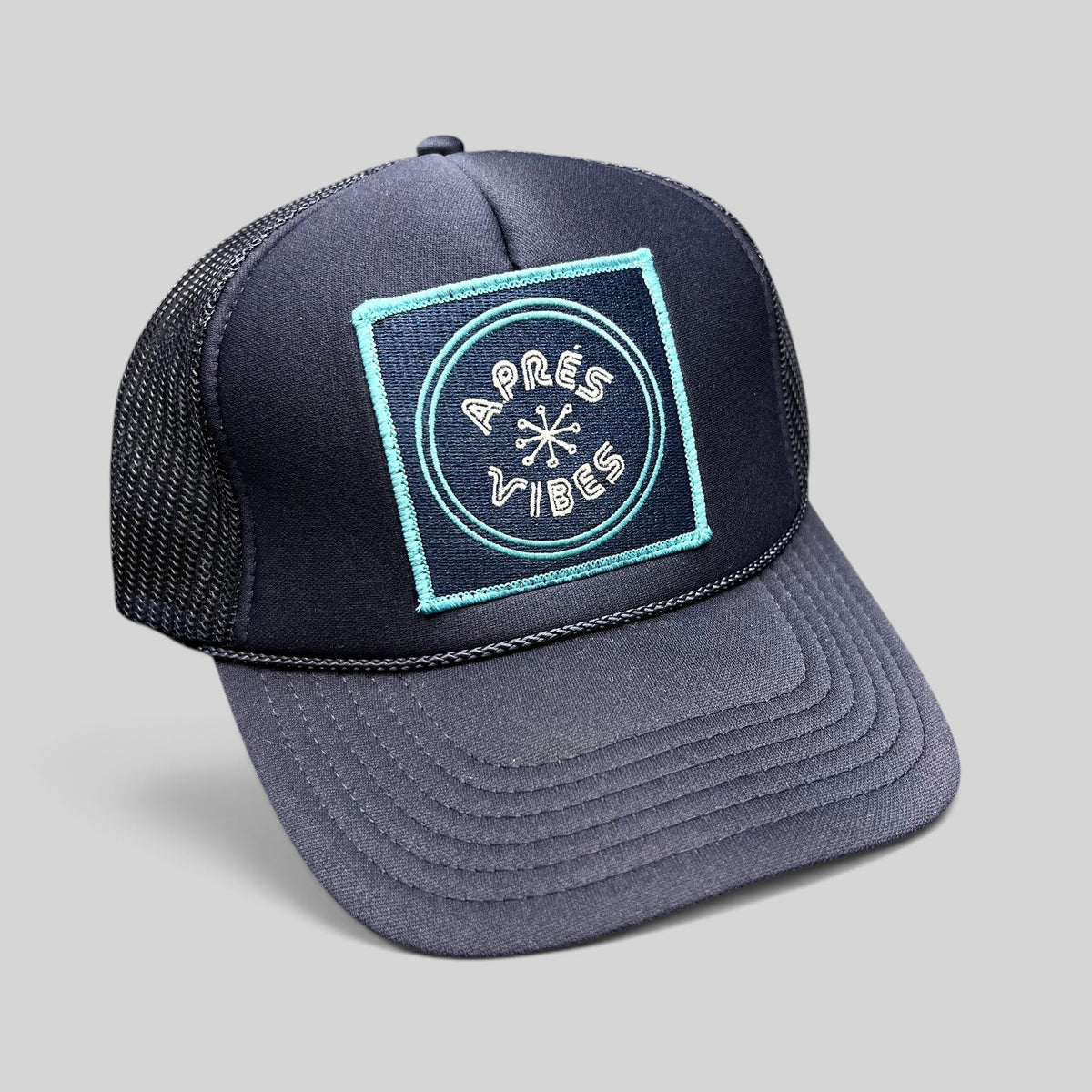 Raree Finds navy blue trucker hat with an Après Vibes embroidered patch and breathable mesh back panel.