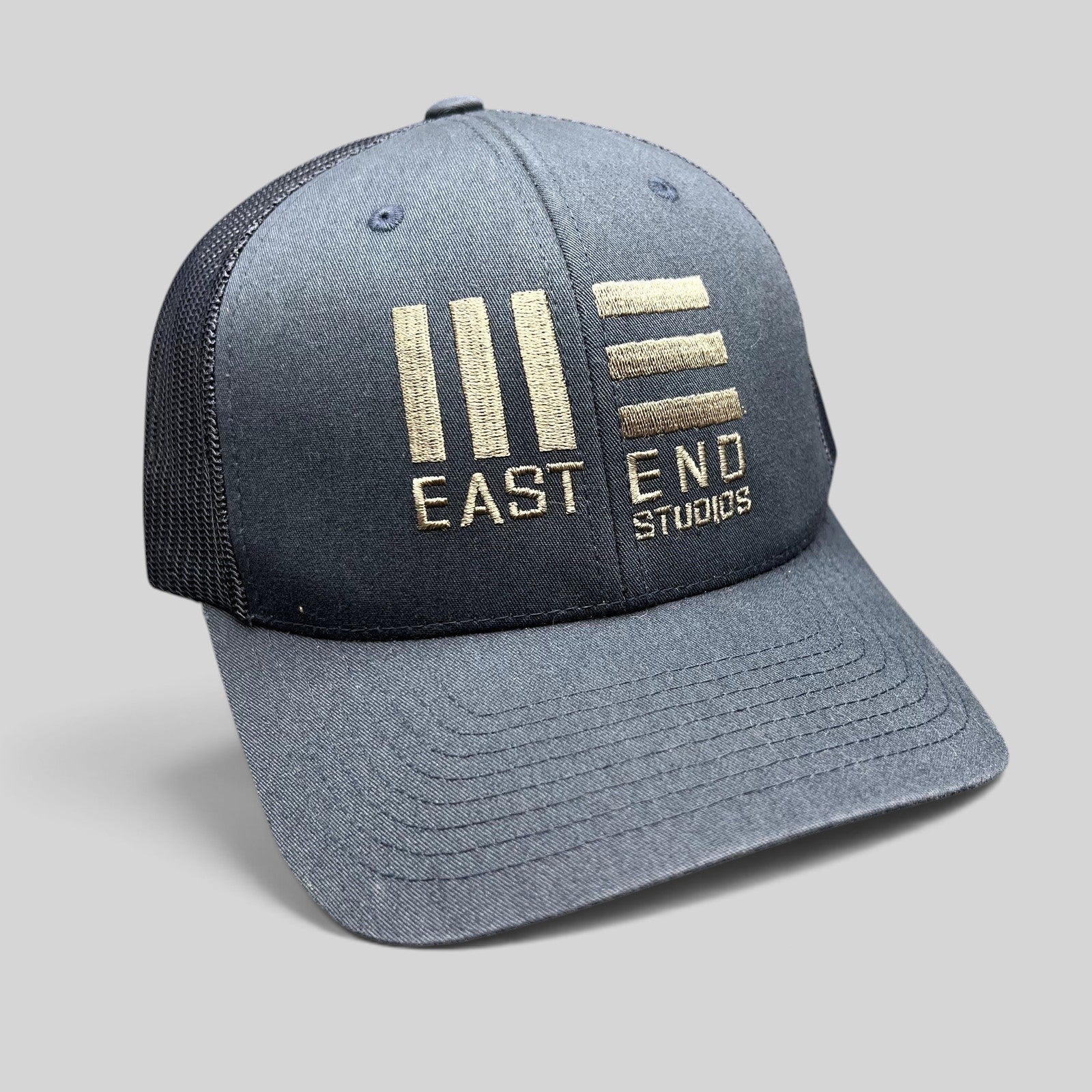 Raree Finds navy blue East End Studios trucker snapback hat with gold embroidered logo and breathable mesh back.