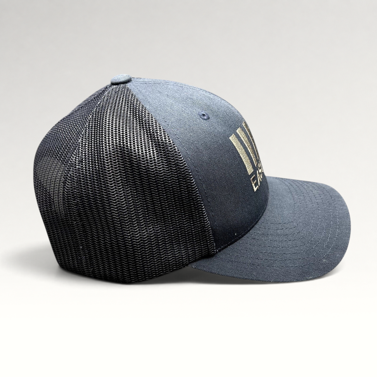 Raree Finds navy blue East End Studios trucker snapback hat with mesh back and embroidered logo, side profile view.