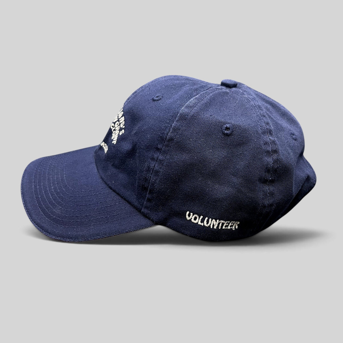 Raree Finds vintage navy blue cotton strapback hat with embroidered Volunteer text from a charity golf tournament