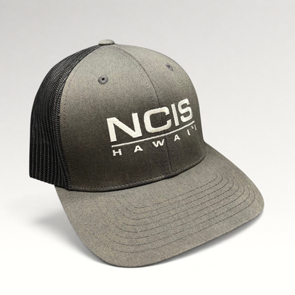 Raree Finds NCIS Hawaii film crew trucker hat with gray structured crown, black mesh back, and white front embroidery.