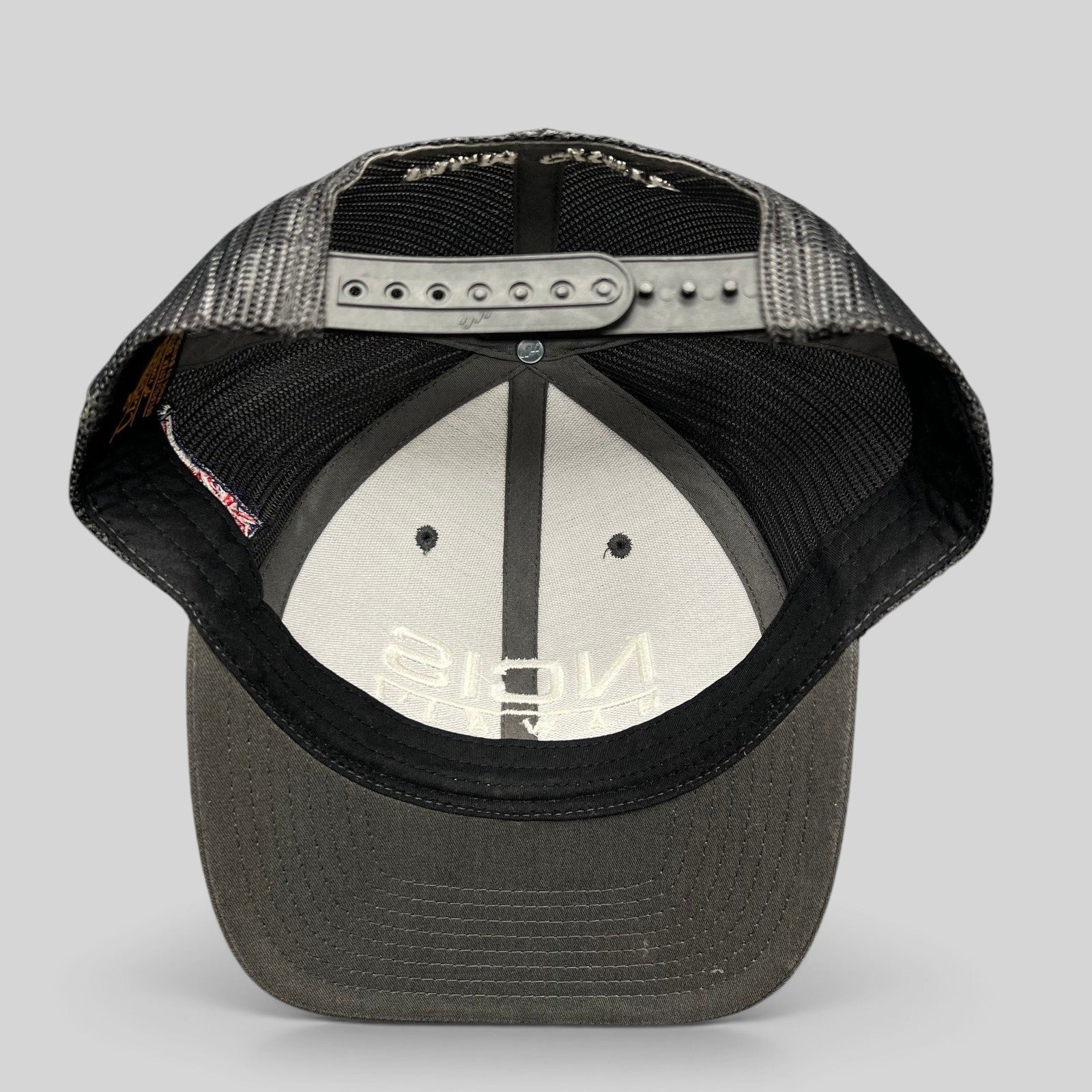 Raree Finds NCIS Hawaii film crew trucker hat with gray structured crown, black mesh back, and adjustable snapback.