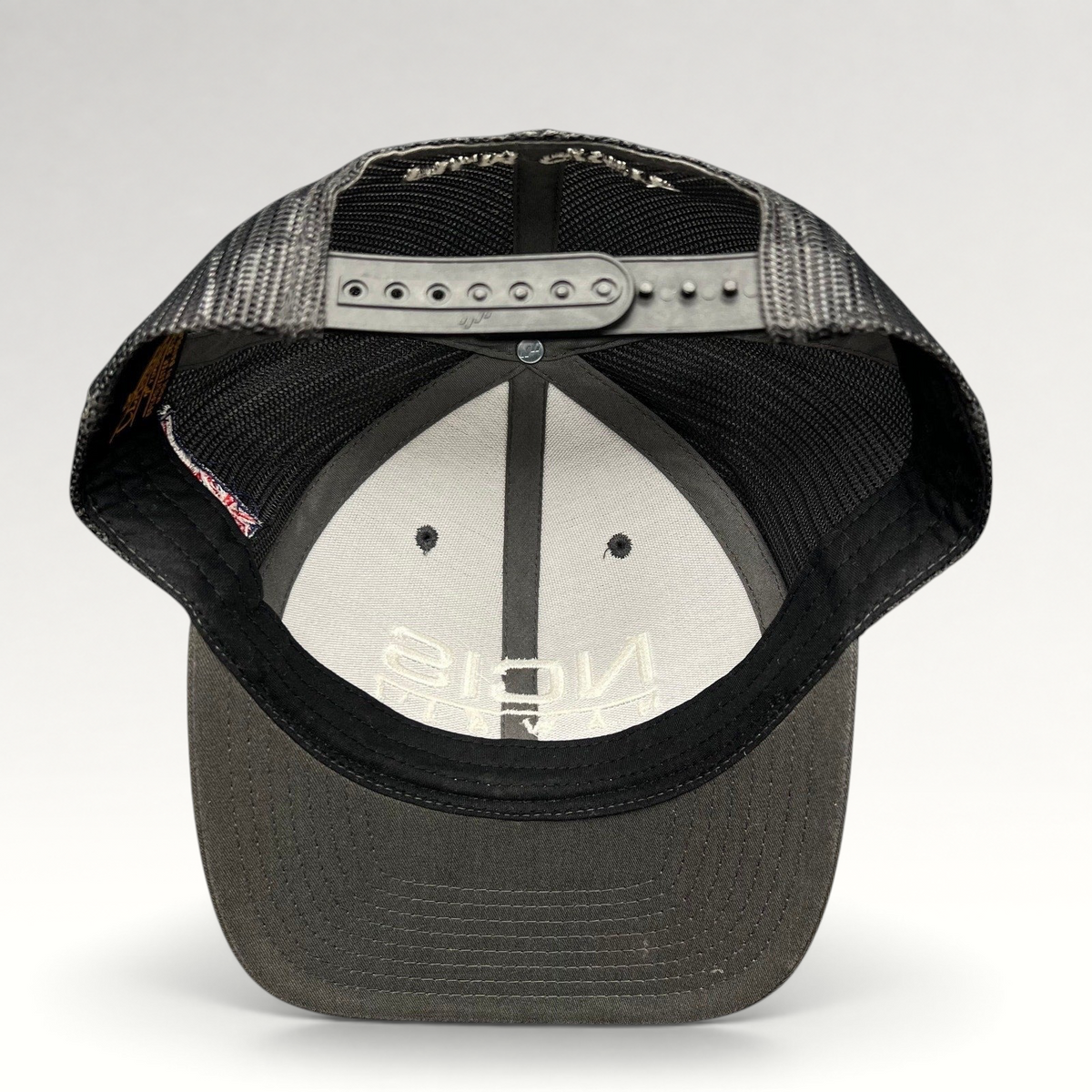 Raree Finds NCIS Hawaii film crew trucker hat with gray structured crown, black mesh back, and adjustable snapback.