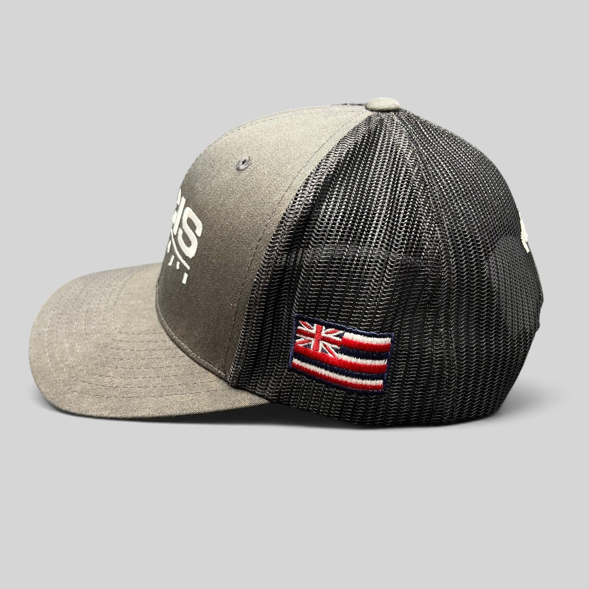 Raree Finds NCIS Hawaii trucker hat in gray and black with white embroidery and a side Hawaii state flag patch
