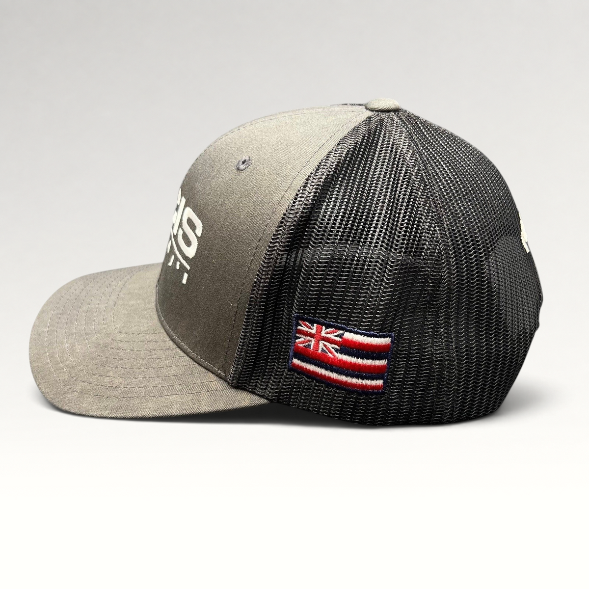 Raree Finds NCIS Hawaii trucker hat in gray and black with white embroidery and a side Hawaii state flag patch