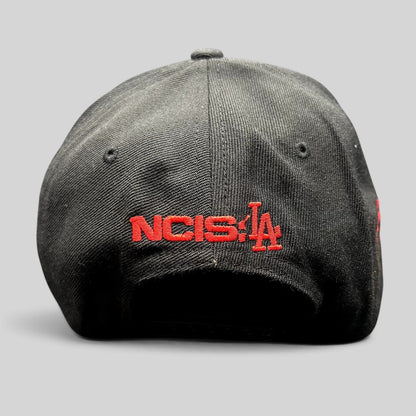 Raree Finds black snapback hat featuring red NCIS LA embroidery on the back, commemorative television show merchandise.