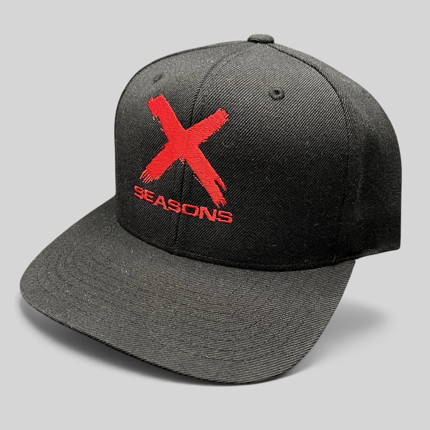 Raree Finds NCIS Los Angeles X Seasons black snapback hat with distressed red embroidered logo and green undervisor.