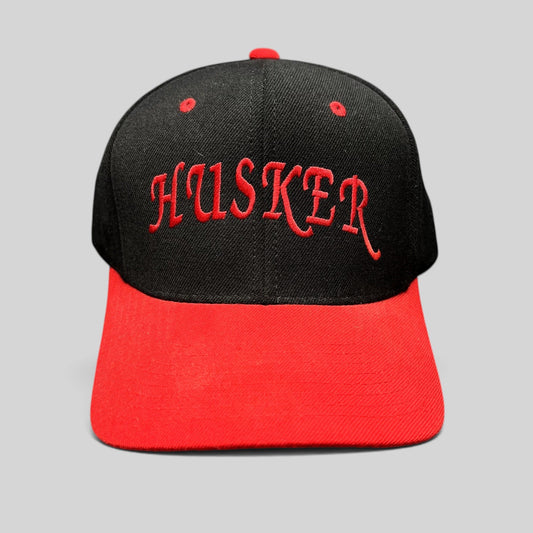Raree Finds vintage Nebraska Cornhuskers snapback hat with black crown, red visor, and embroidered Husker script.