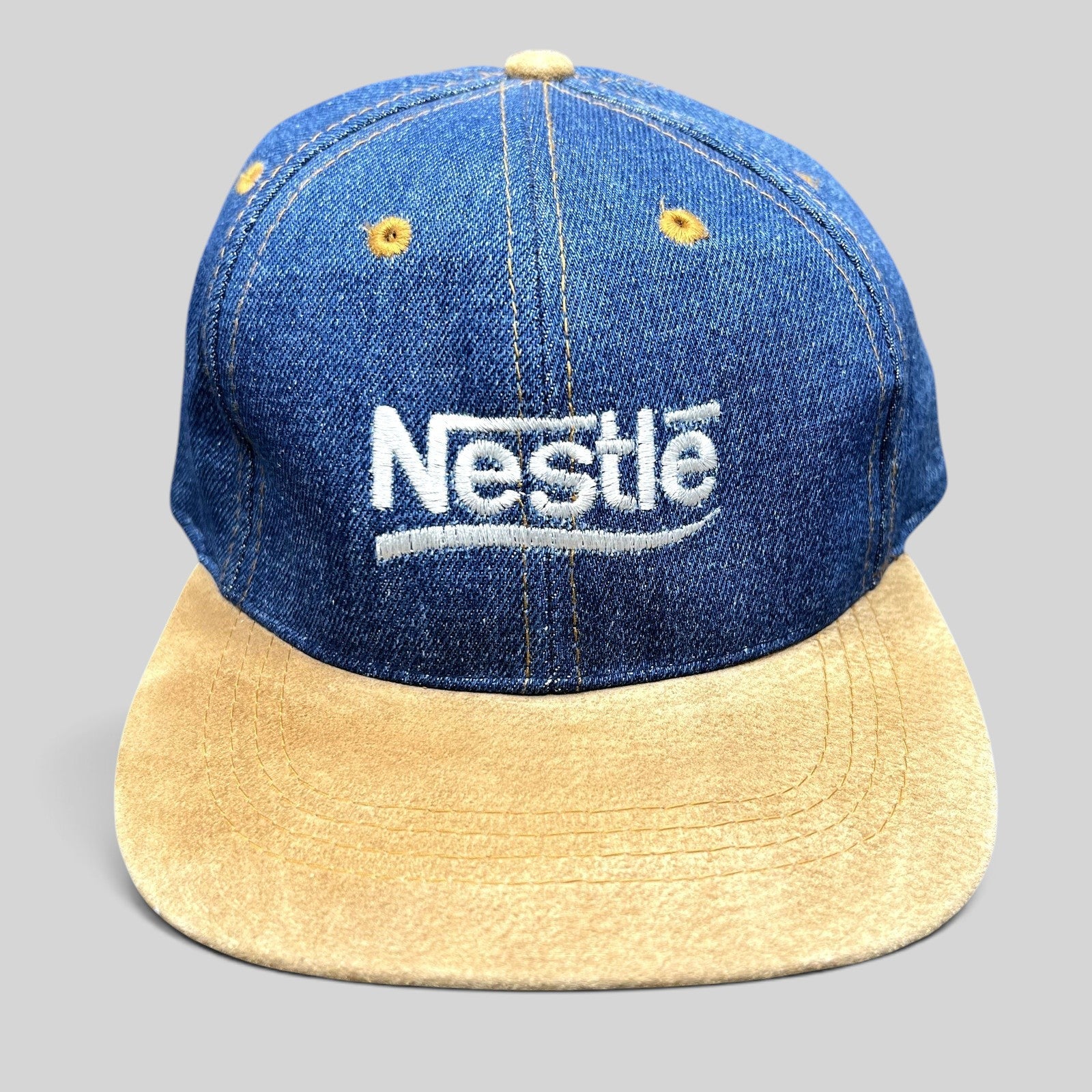 Raree Finds vintage Nestlé strapback hat with indigo denim crown, tan suede brim, and white embroidered logo