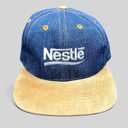 Raree Finds vintage Nestlé strapback hat with indigo denim crown, tan suede brim, and white embroidered logo