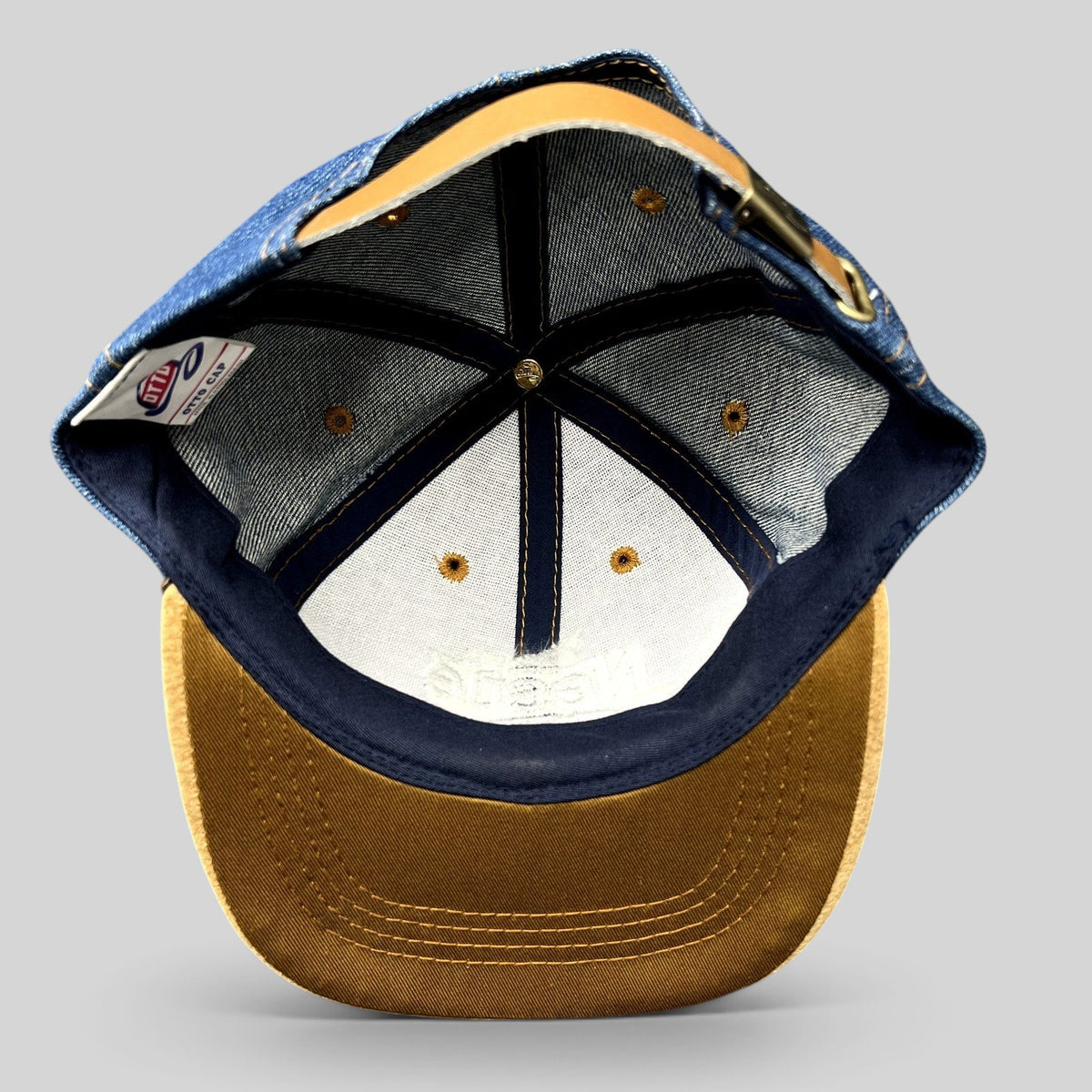 Raree Finds vintage Nestlé Otto Cap featuring a dark indigo denim crown, tan suede brim, and leather strapback closure.