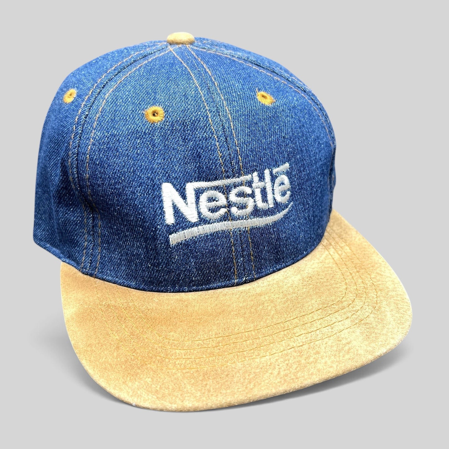 Raree Finds vintage Nestlé promotional hat with indigo denim crown, tan suede brim, and adjustable leather strapback.
