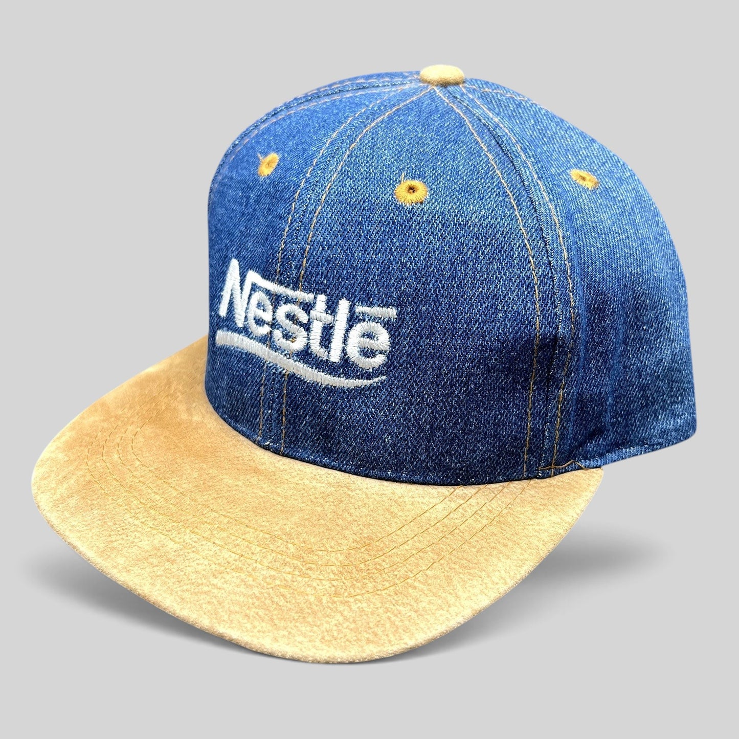 Raree Finds vintage Nestlé strapback hat with indigo denim crown, tan suede brim, and white embroidered logo