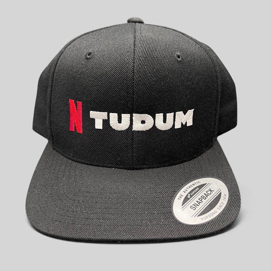 Raree Finds Netflix Tudum promotional black snapback hat with red N and white TUDUM embroidery on a Yupoong base.