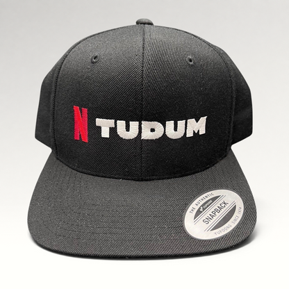 Raree Finds Netflix Tudum promotional black snapback hat with red N and white TUDUM embroidery on a Yupoong base.