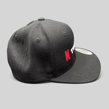 Raree Finds Netflix Tudum promotional snapback hat in black with red and white embroidery and a flat brim.