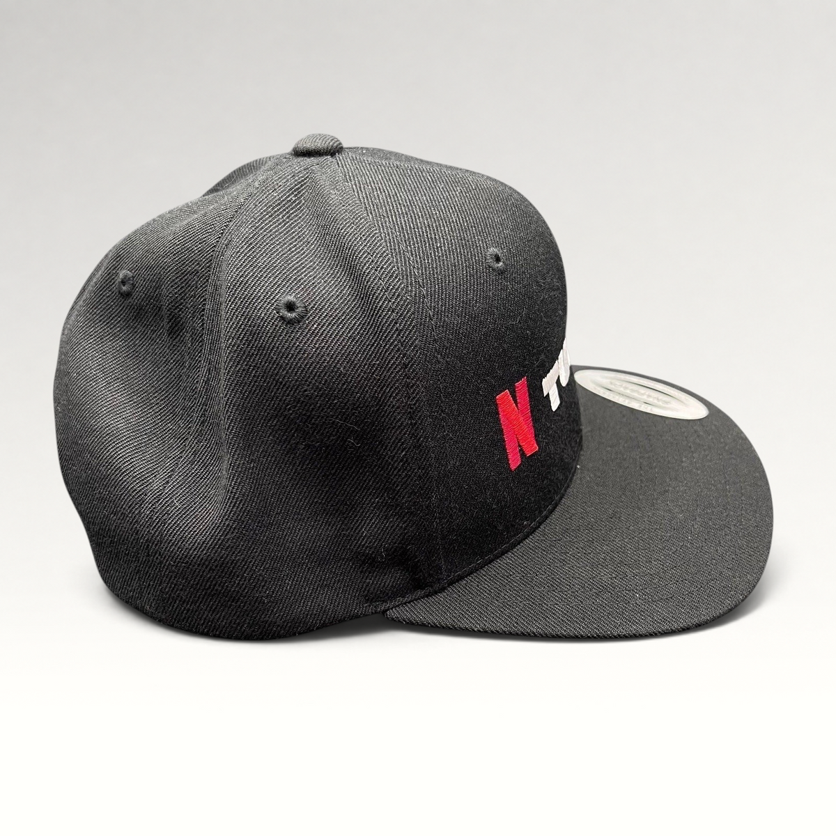 Raree Finds Netflix Tudum promotional snapback hat in black with red and white embroidery and a flat brim.