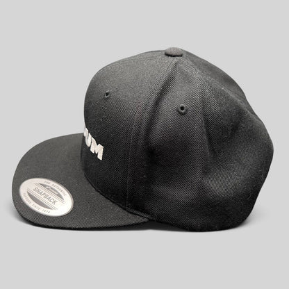 Raree Finds black Netflix Tudum snapback hat with white embroidered lettering and Yupoong flat brim design