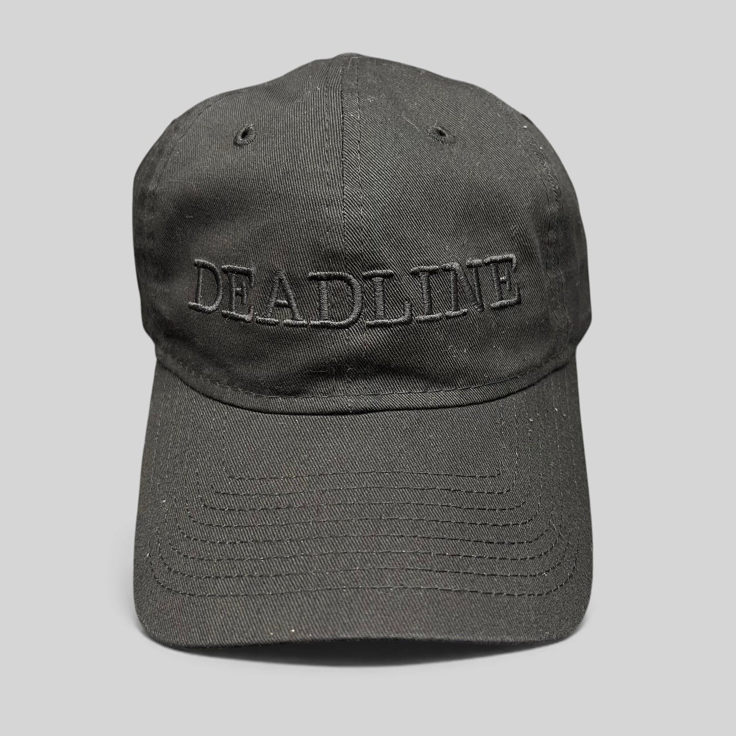 Raree Finds New Era 9TWENTY black cotton strapback hat with tonal DEADLINE embroidery and a curved brim