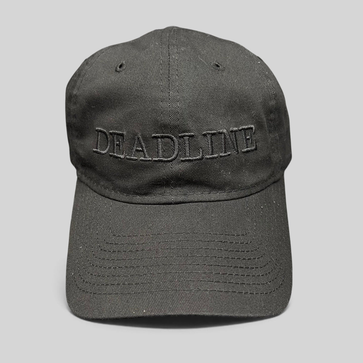 Raree Finds New Era 9TWENTY black cotton strapback hat with tonal DEADLINE embroidery and a curved brim