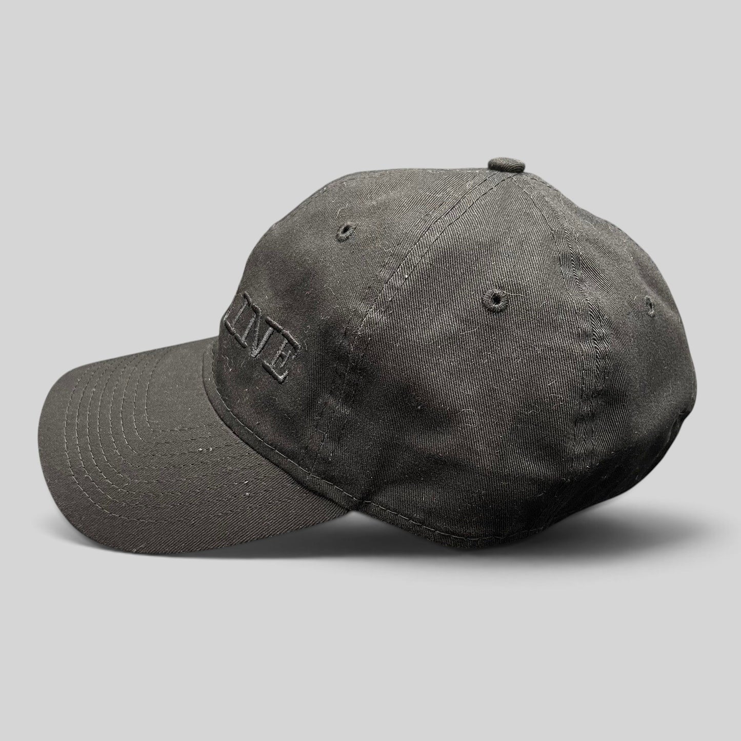 Raree Finds New Era 9TWENTY black cotton strapback hat with tonal DEADLINE embroidery and curved brim side view