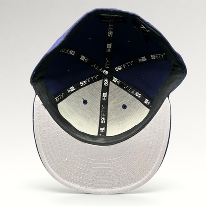 Interior view of a Raree Finds New Era 59FIFTY navy fitted hat showing branded taping and size 7 1/4 label.