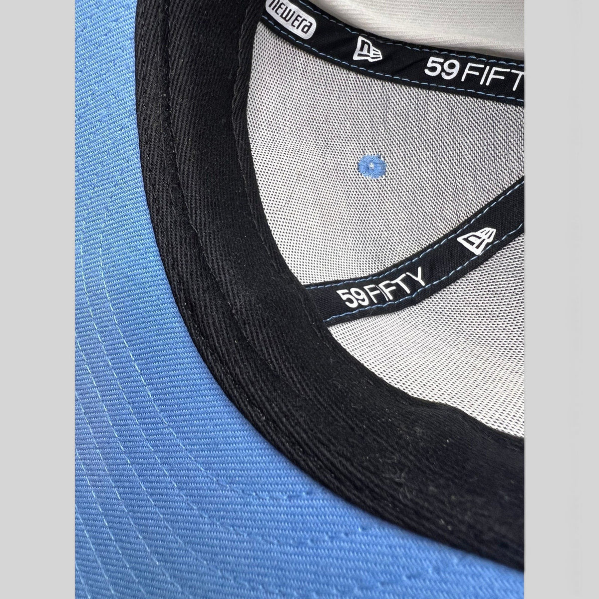 Raree Finds New Era 59FIFTY fitted hat interior showing black sweatband, logo tape, and light blue crown lining
