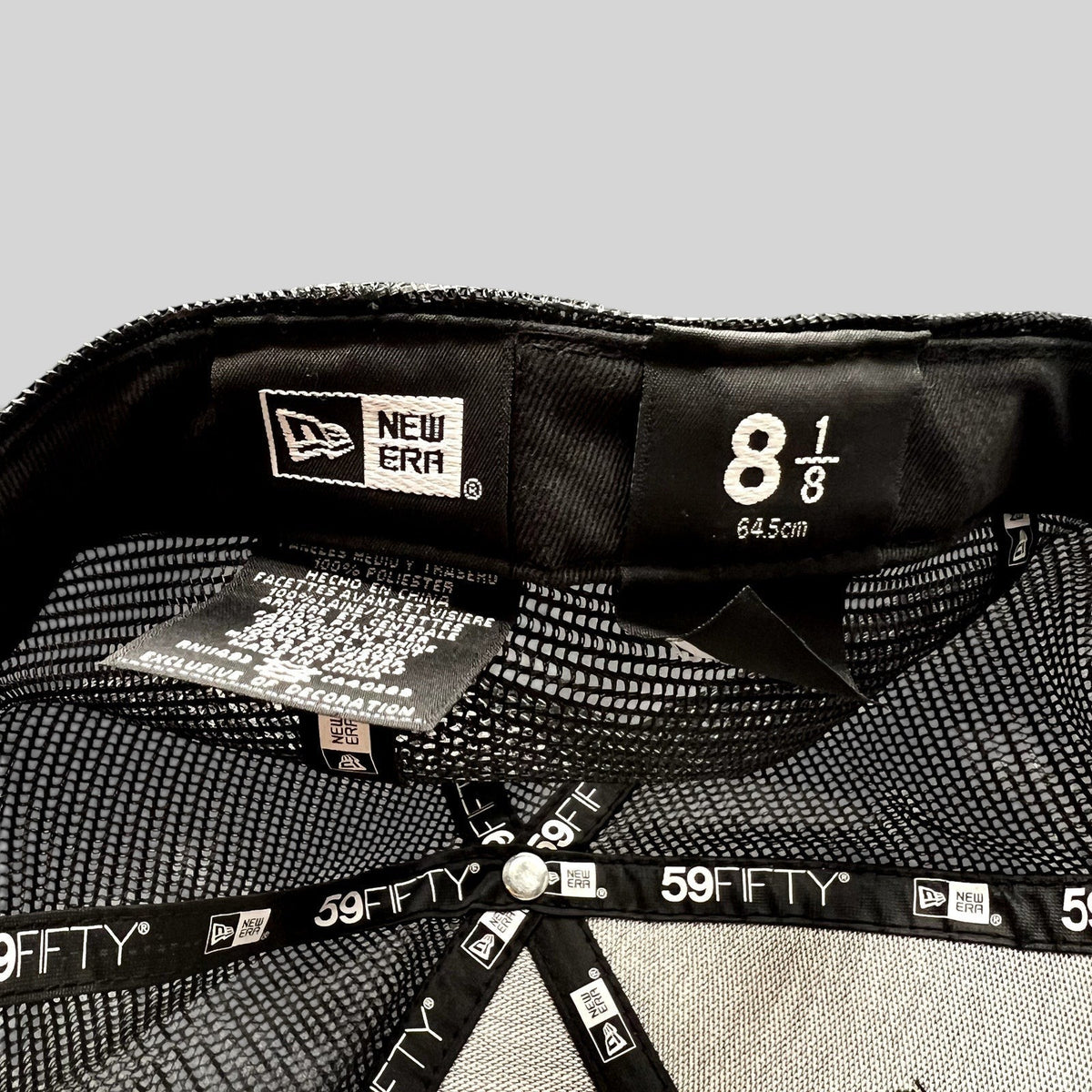 Raree Finds New Era 59FIFTY black trucker hat interior showing size 8 1/8 label and branded taping on mesh panels