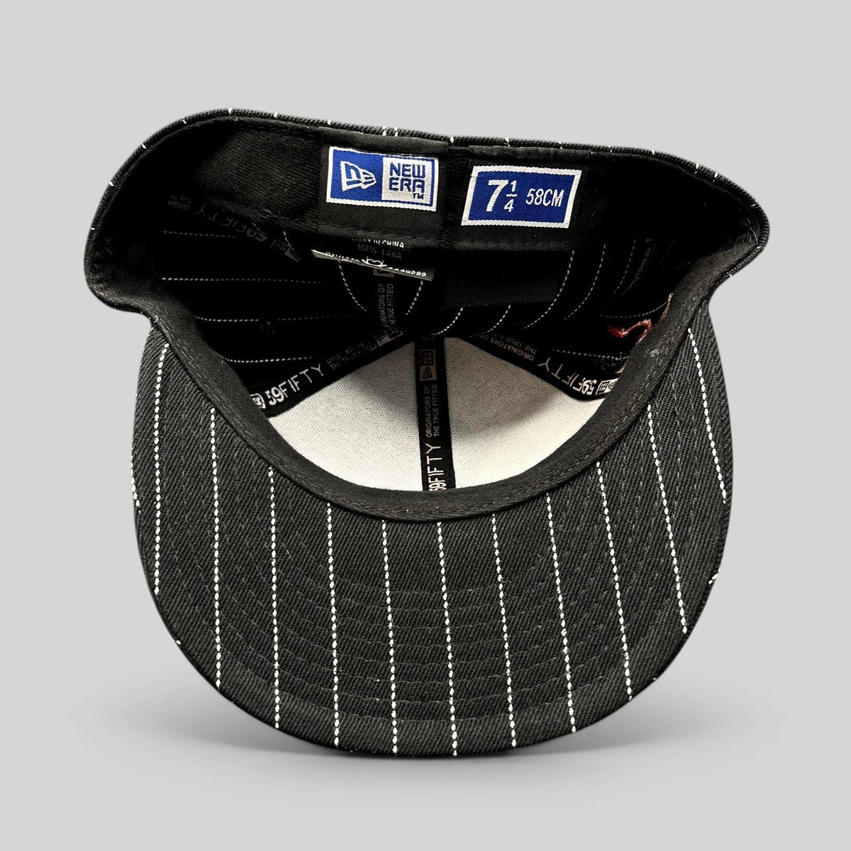 Raree Finds New Era 59FIFTY fitted hat interior showing black and white pinstripe pattern and size 7 1/4 label
