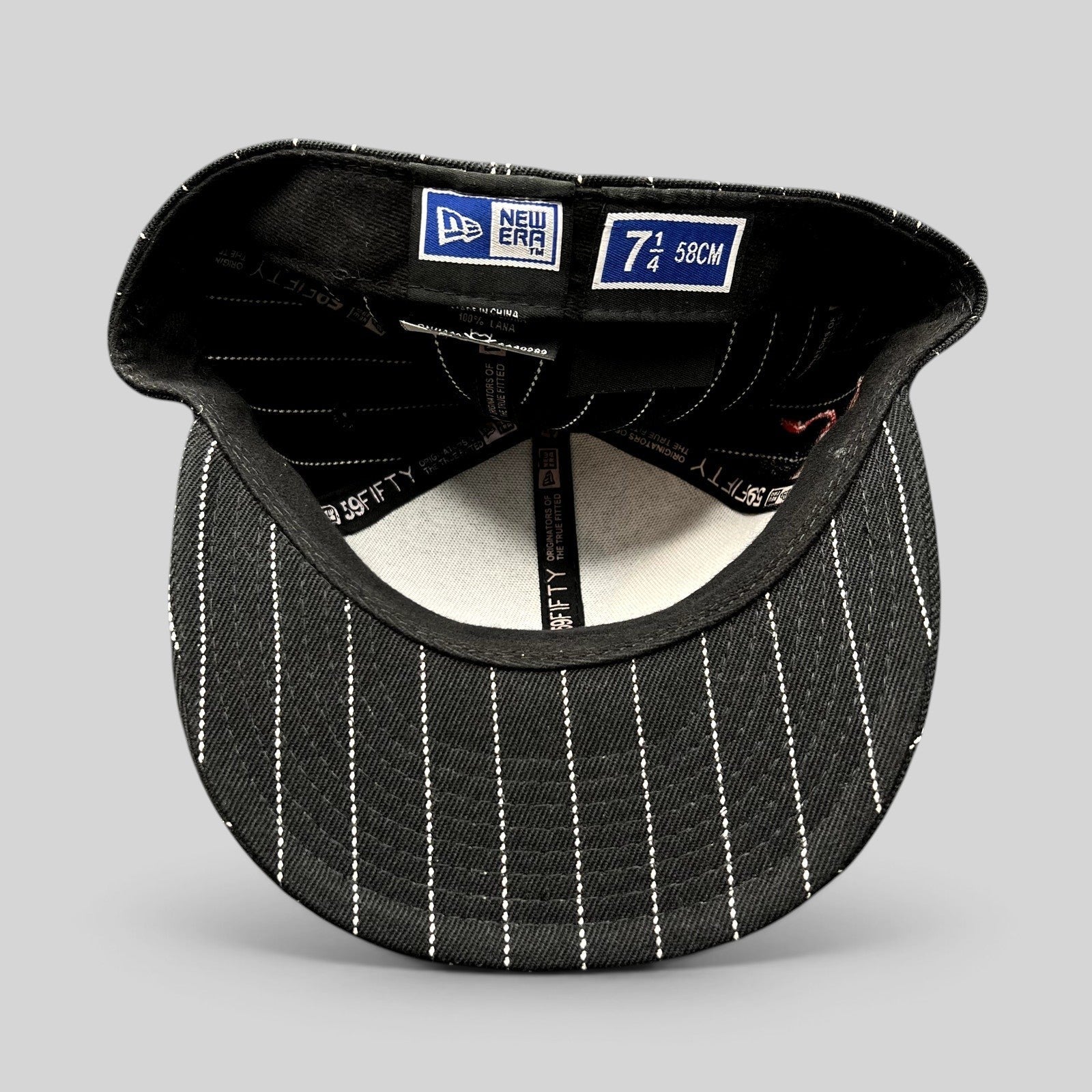 Raree Finds New Era 59FIFTY fitted hat interior showing black and white pinstripe pattern and size 7 1/4 label