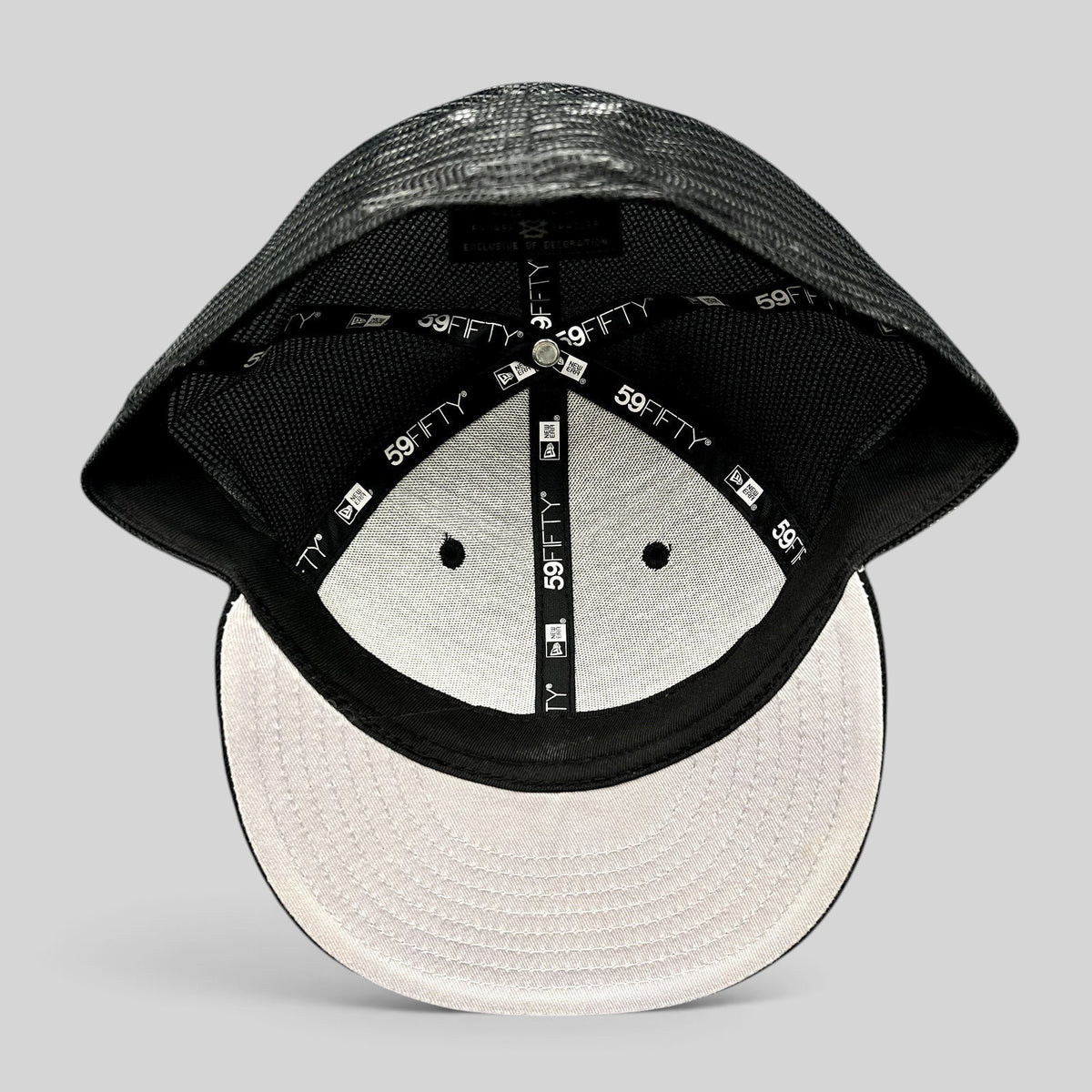 Raree Finds New Era 59FIFTY blank black trucker fitted hat interior showing branded taping and mesh back construction