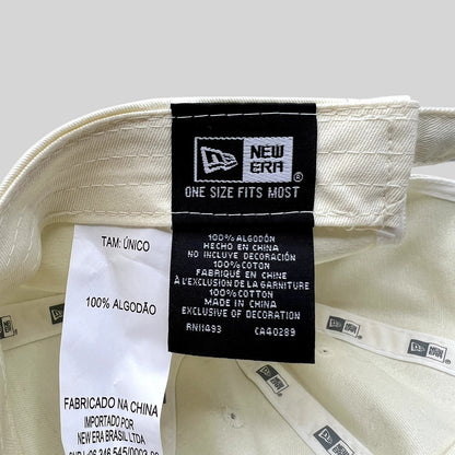 Raree Finds cream New Era strapback hat interior label showing 100% cotton material and manufacturing details