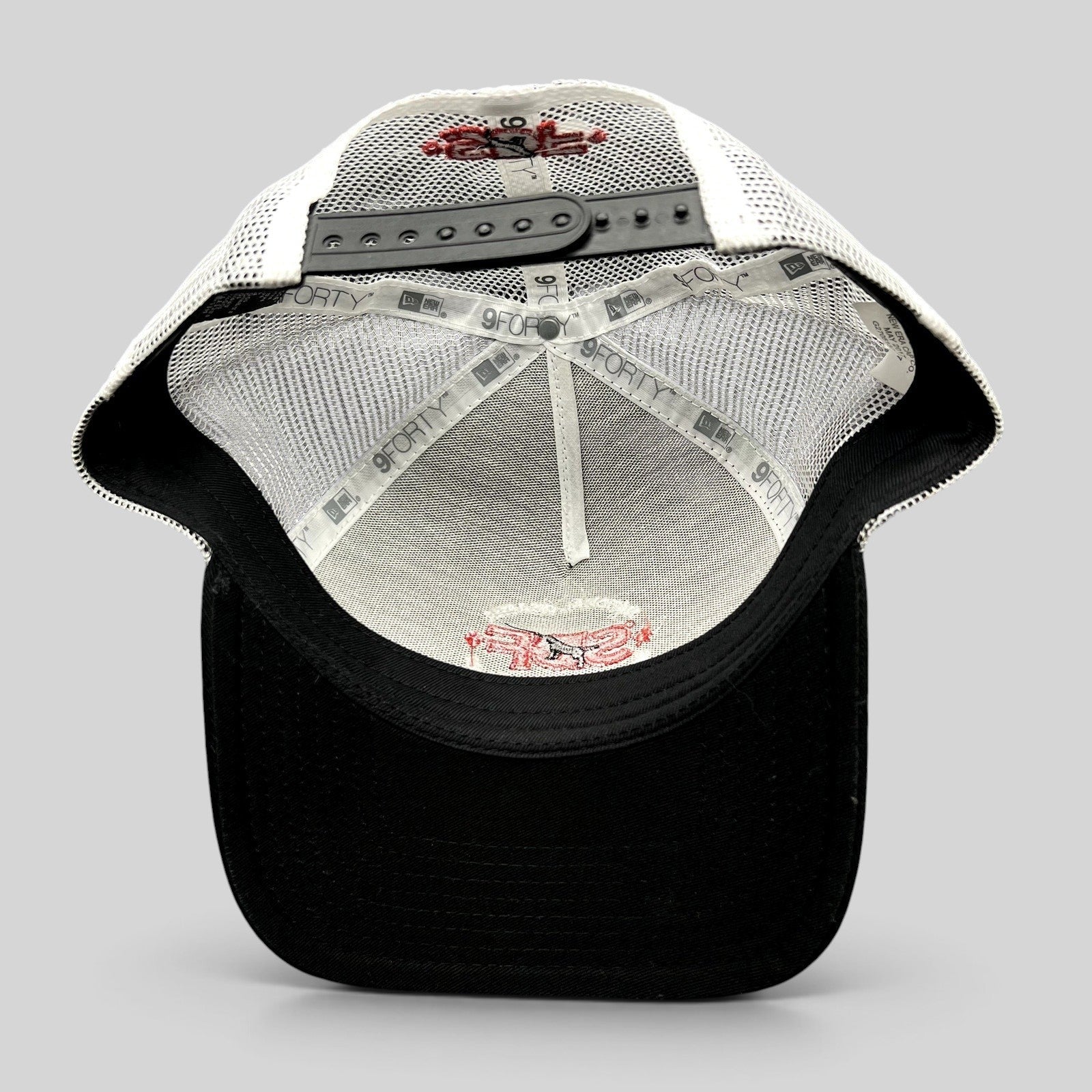Raree Finds New Era 9FORTY SDF trucker hat interior showing white mesh, black brim, and embroidered logo details.