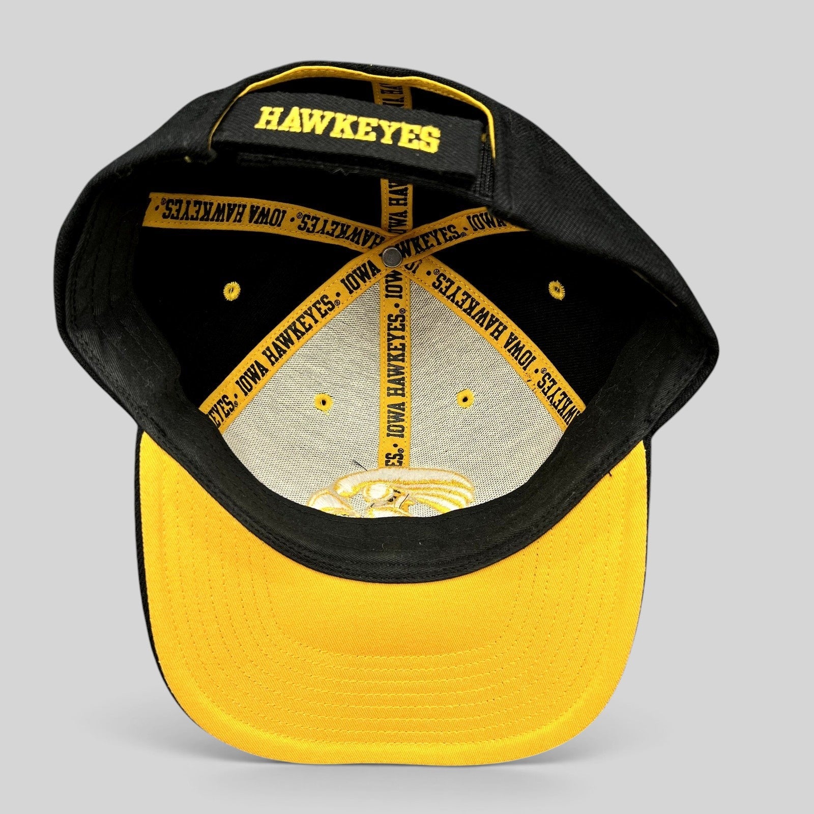 Raree Finds vintage Nike Iowa Hawkeyes strapback hat showing interior branded taping and gold embroidery on black