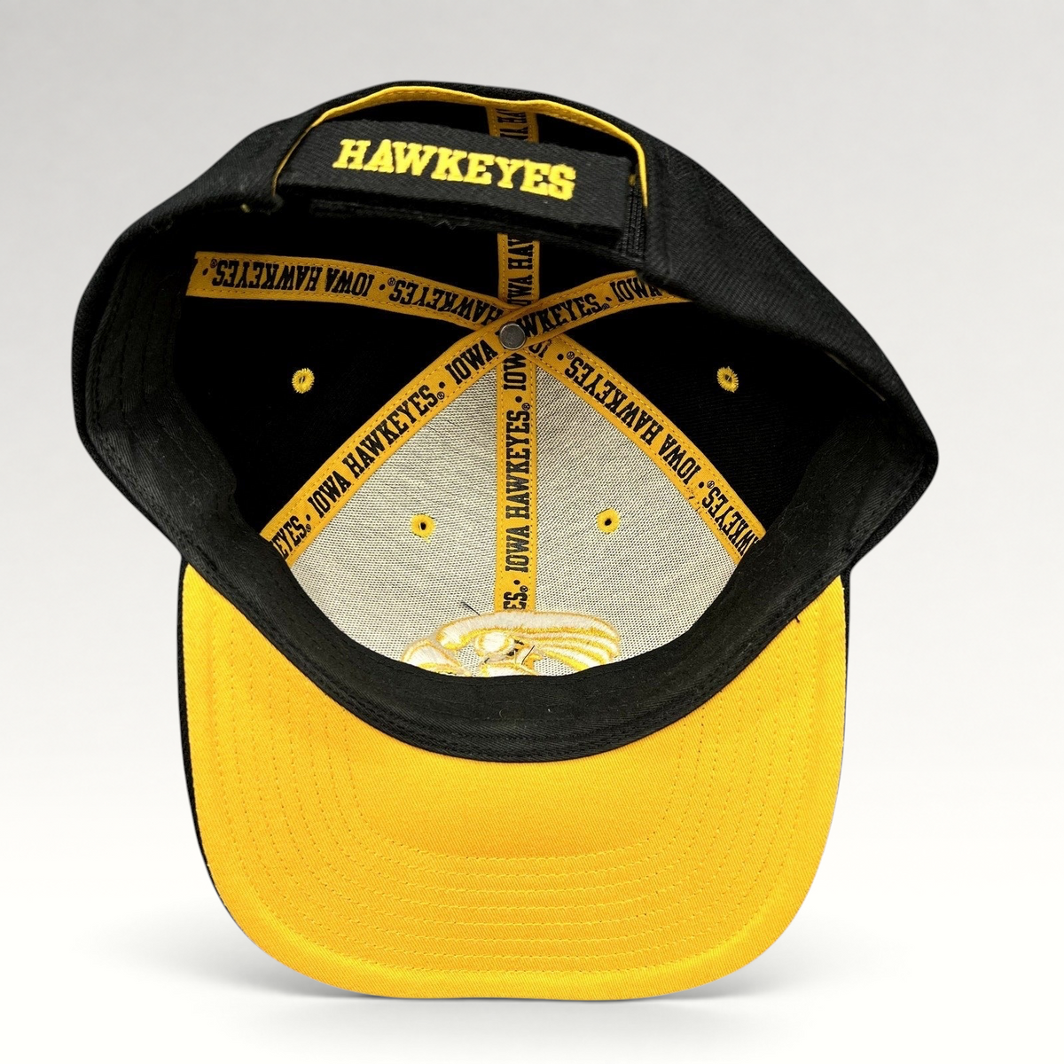 Raree Finds vintage Nike Iowa Hawkeyes strapback hat showing interior branded taping and gold embroidery on black