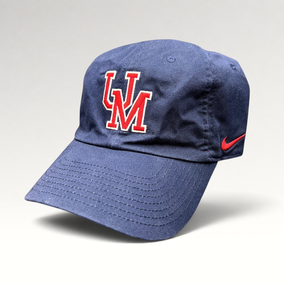 Raree Finds navy blue Nike Heritage86 University of Mobile strapback hat with red and white UM logo and side swoosh.