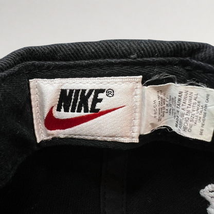 Raree Finds vintage 90s Nike snapback cap interior tag showing brand logo and manufacturing details on black cotton